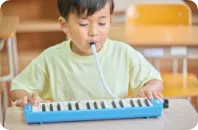 鍵盤ハーモニカを演奏する子供